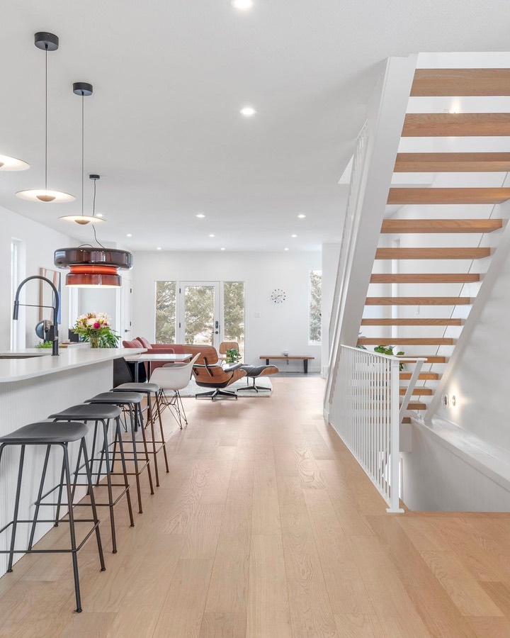 Open-plan kitchen and floating wood staircase in a modern home