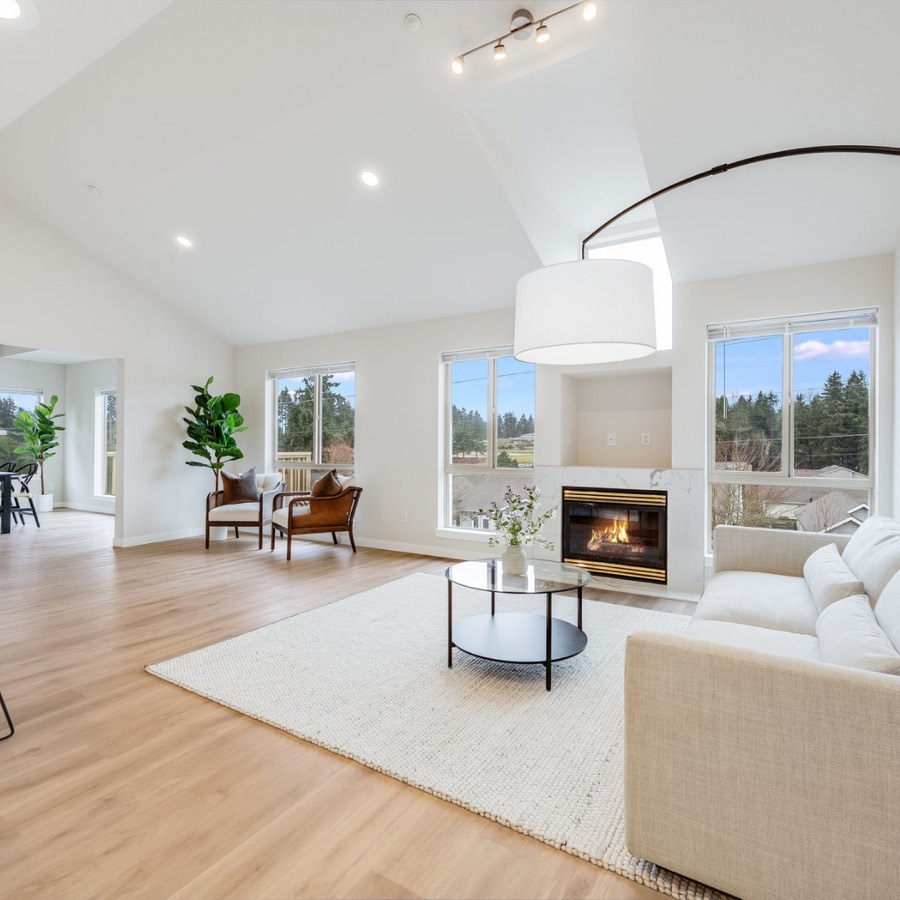 Bright vaulted living room with fireplace and large windows