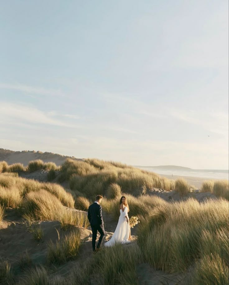 Couple walking the dunes in wedding attire